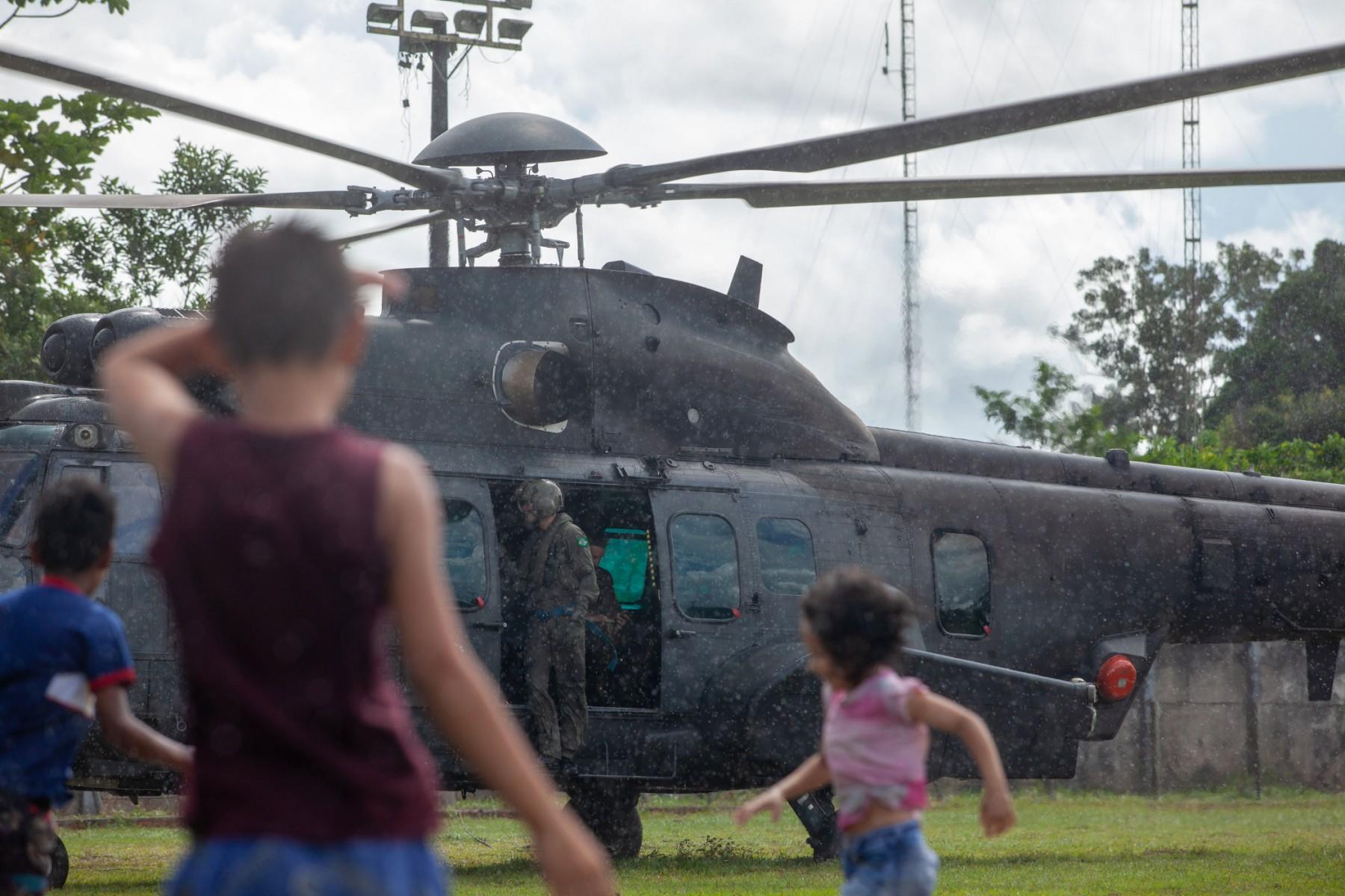 Children play next to a Brazilian army helicopter taking part in the search for missing indigenist Bruno Pereira and journalist Dom Phillips, in the municipality of Atalaia do Norte, state of Amazonas, Brazil on June 10. Photo: AFP
