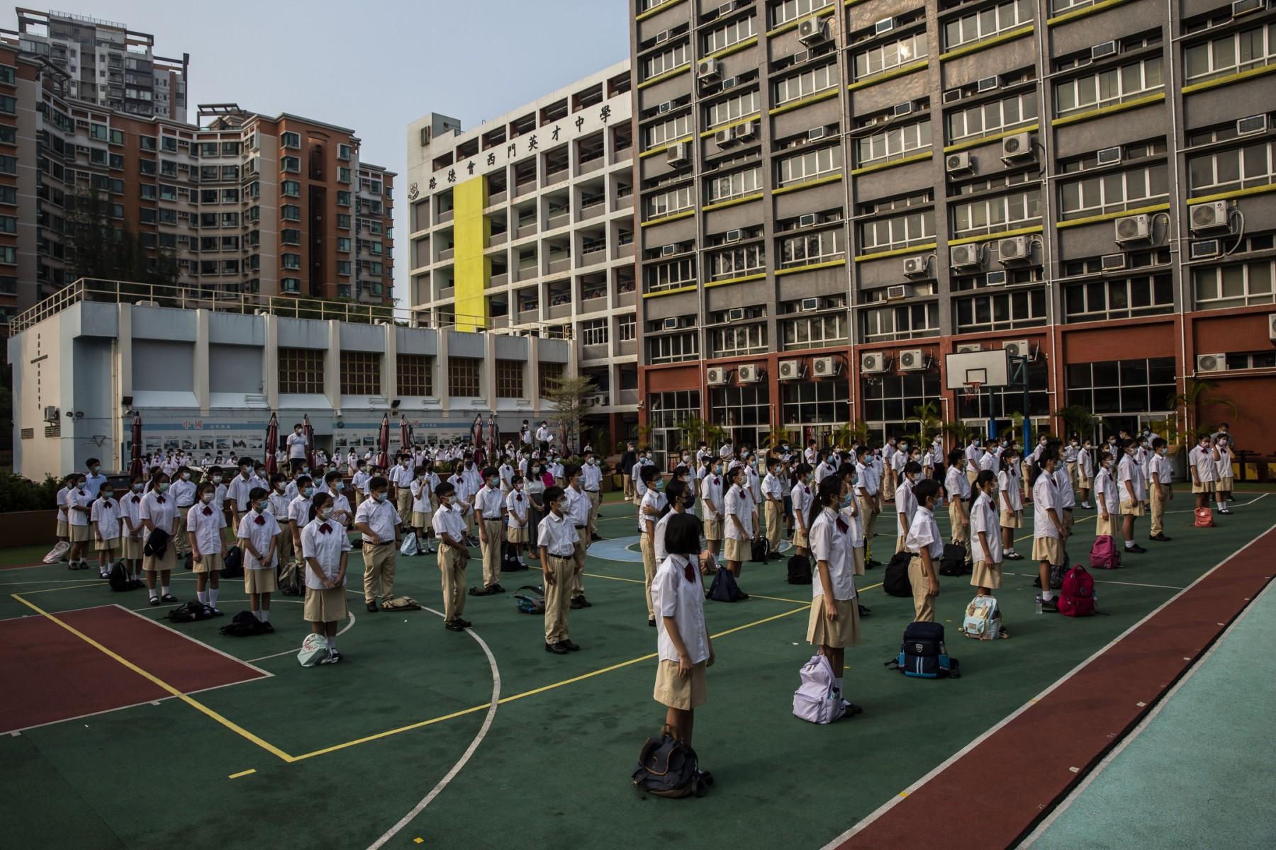 Student watch a flag raising ceremony at a school in the Yuen Long district of Hong Kong on Sept 30, 2021. Photo: AFP