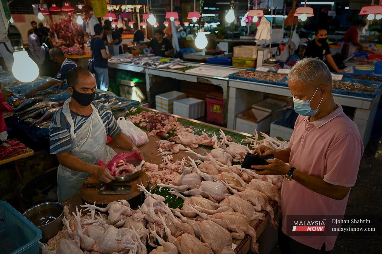 Seorang pelanggan membeli ayam di Pasar Datuk Keramat, Kuala Lumpur. Malaysia menghentikan eksport ayam bulan ini sehingga pengeluaran dan kos dalam negara stabil.