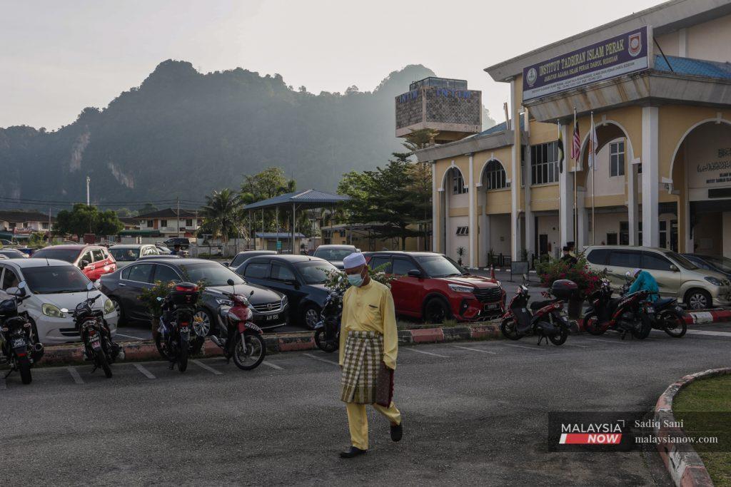 Seorang lelaki berbaju Melayu lengkap menuju ke masjid untuk mengerjakan solat Hari Raya Aidiltfitri baru-baru ini.