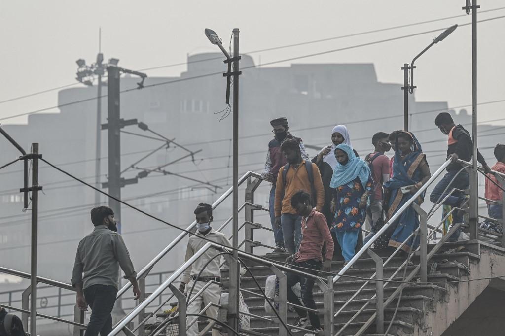 Orang ramai menuruni tangga jejantas di New Delhi pada 12 November 2021. Gambar: AFP 