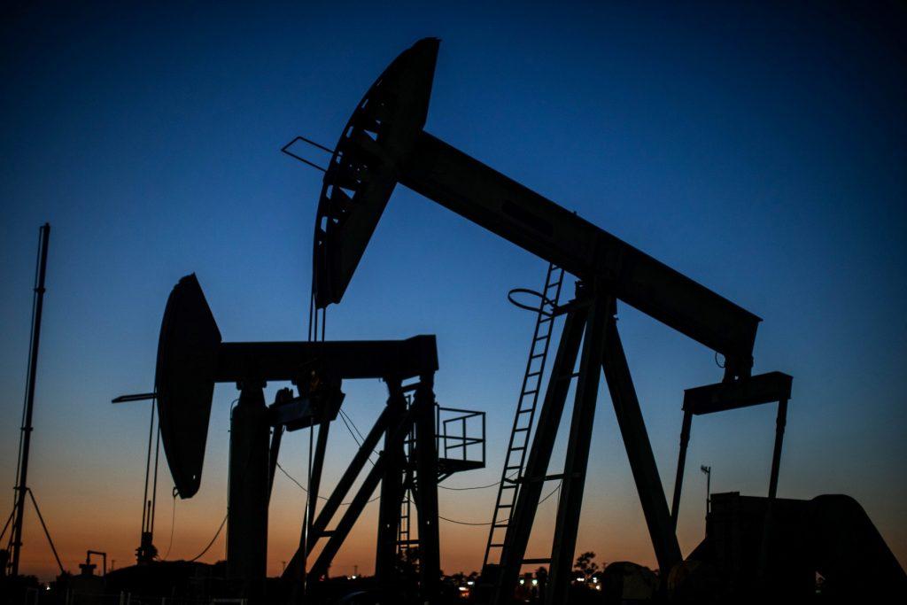 Oil pumpjacks operate at dusk Willow Springs Park in Long Beach, California on April 21, 2020. Photo: AFP