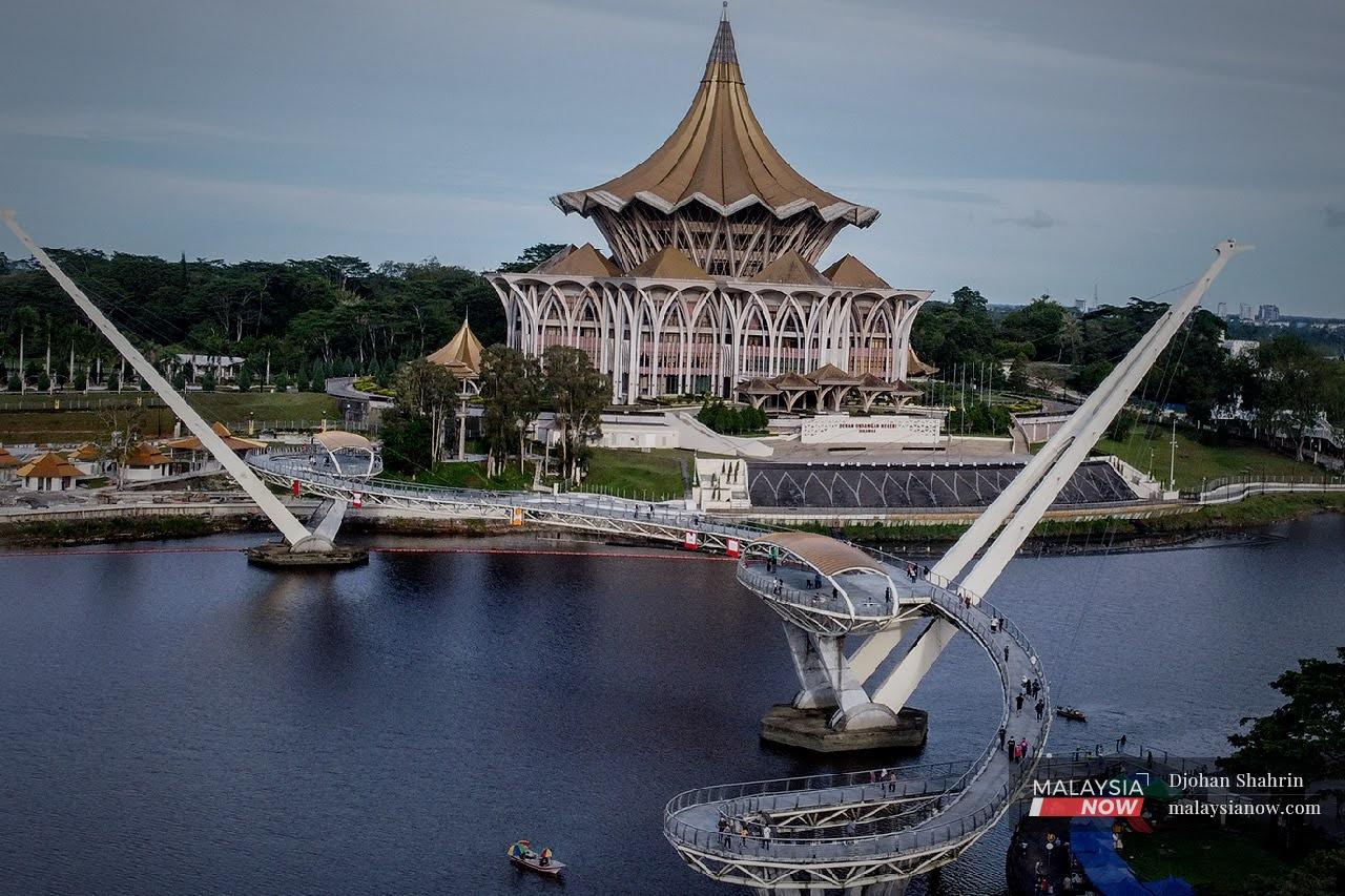Tourists cross the Darul Hana bridge at the Waterfront, near the state legislative assembly building in Kuching.