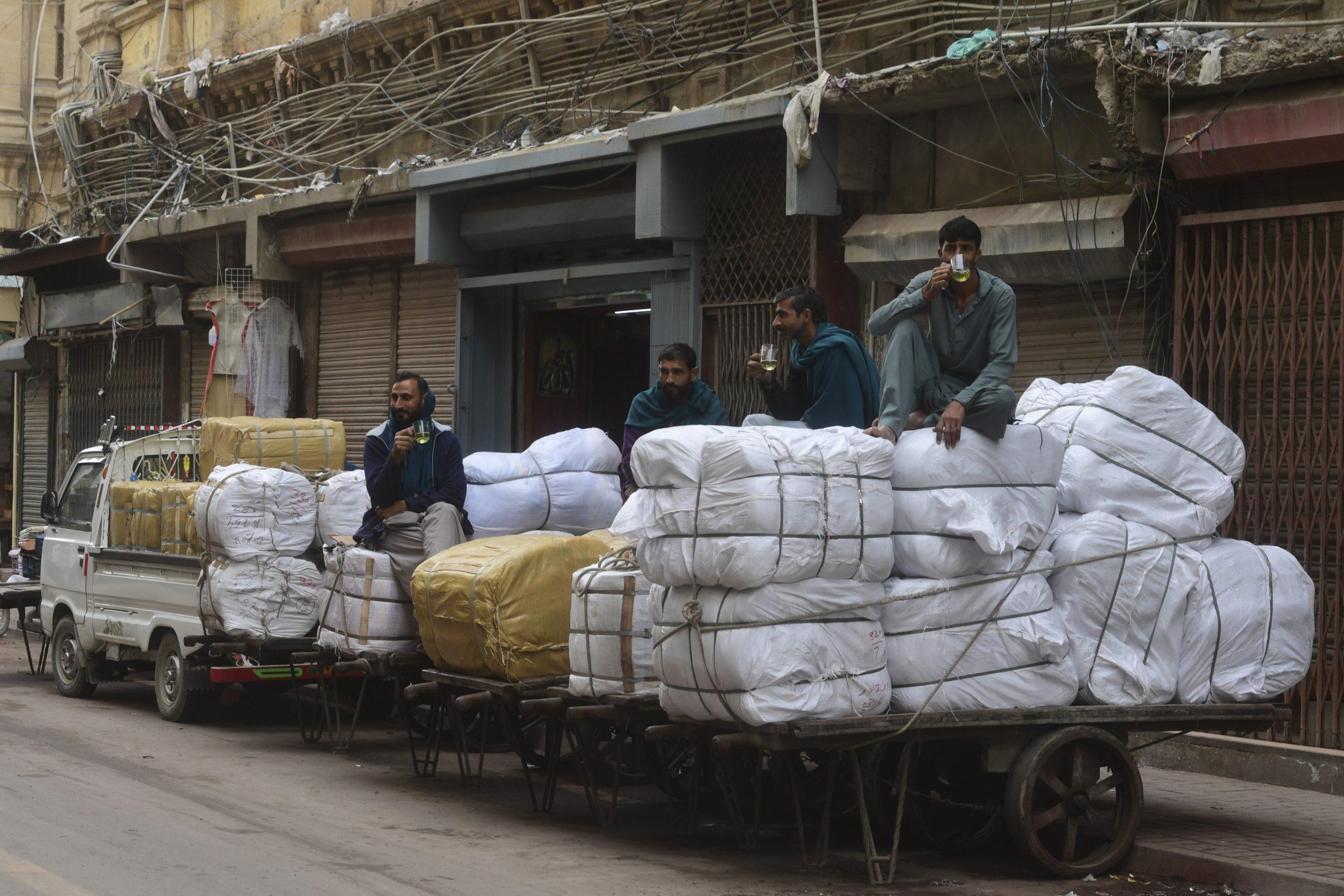 Labourers drink tea over their loaded carts at a market area in Karachi on Jan 6. Photo: AFP