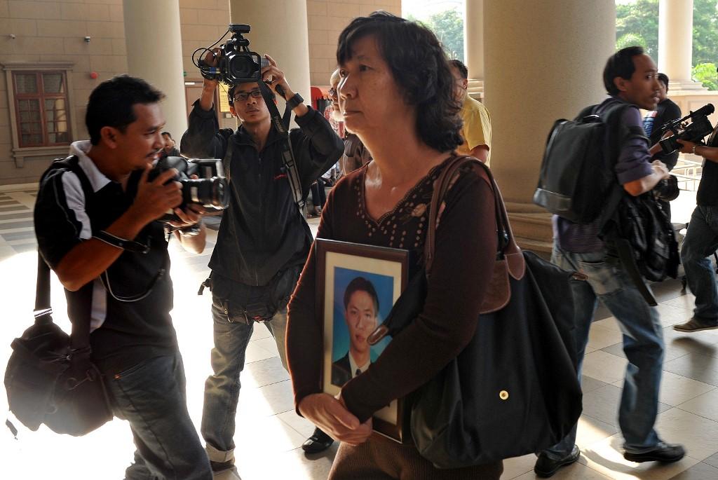 Teoh Beng Hock's mother, Teng Shuw Hor, holds his portrait at the court complex in Kuala Lumpur in this file picture taken Feb 12, 2011. Photo: AFP