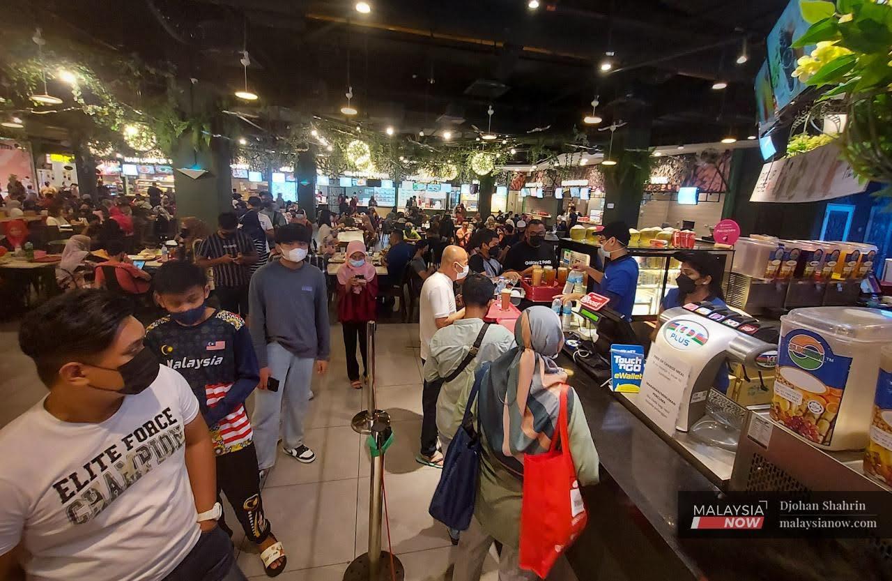 Orang ramai menjamu selera di pasar raya Sogo, Kuala Lumpur. Langkah memakai pelitup muka masih diamalkan ramai di kawasan tertutup.