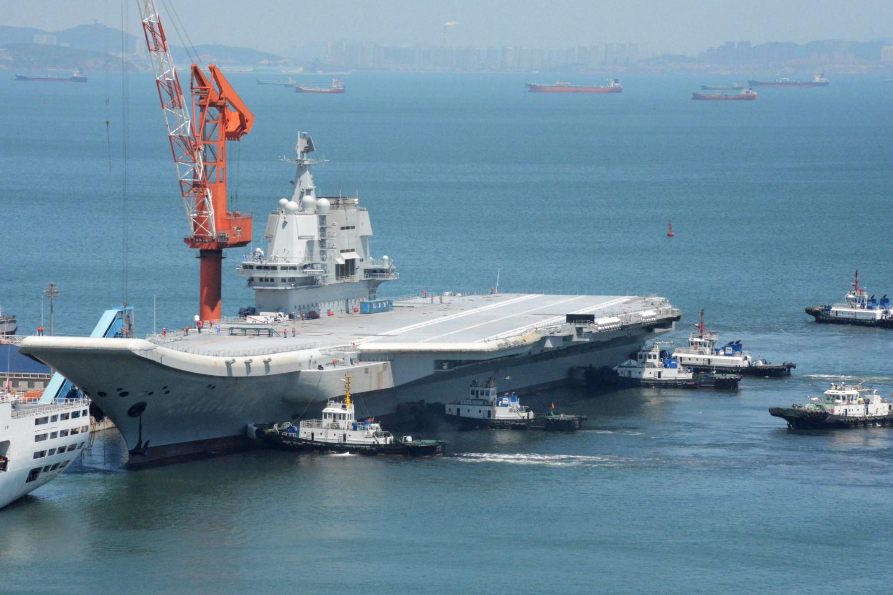 This photo taken on May 18, 2018 shows tugs guiding China's first domestically manufactured aircraft carrier, known as 'Type 001A', as it returns to port in Dalian in China's northeastern Liaoning province after its first sea trial. Photo: AFP