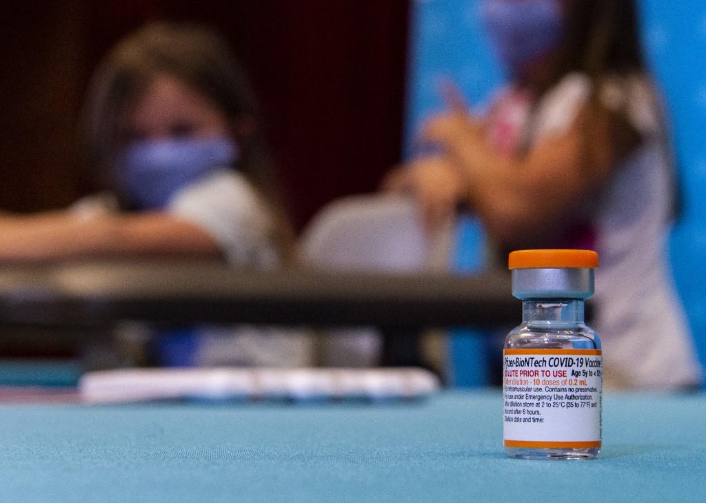 In this file photo taken on Nov 2, 2021 a vial of the new children's dose of the Pfizer-BioNTech Covid-19 vaccine sits in the foreground as children play in a hospital room waiting to be able to receive the vaccine at Hartford Hospital in Hartford, Connecticut. Photo: AFP