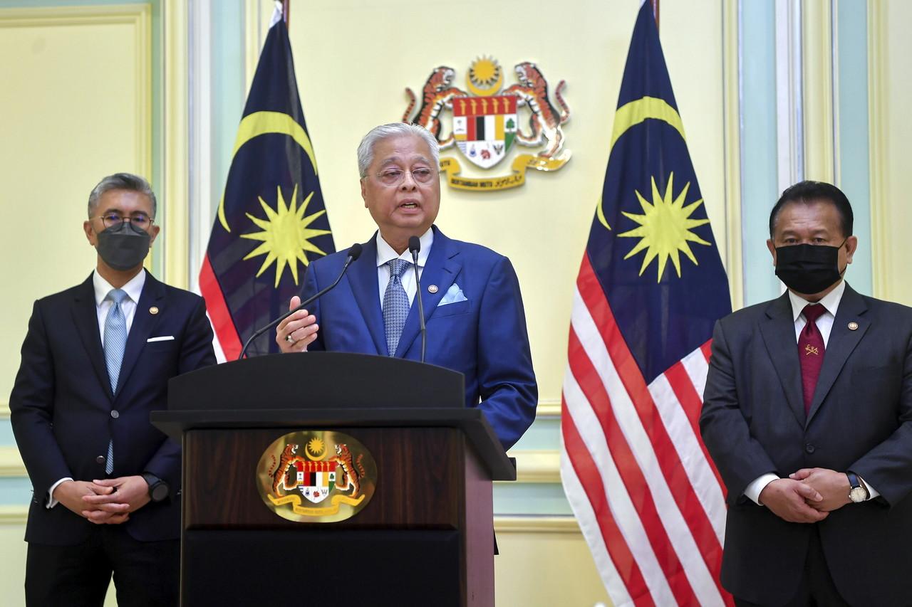 Prime Minister Ismail Sabri Yaakob speaks in a live address in Putrajaya today, flanked by Finance Minister Tengku Zafrul Aziz (left) and Domestic Trade and Consumer Affairs Minister Alexander Nanta Linggi (right). Photo: Bernama