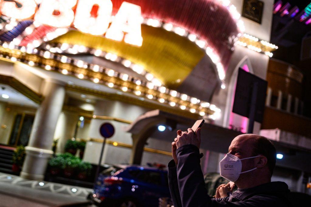 A man wears a face mask as he takes pictures outside a casino in Macau on Jan 30, 2020. Photo: AFP
