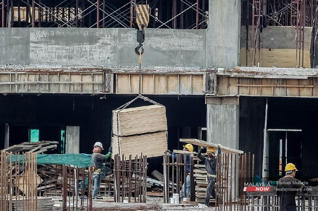 Buruh binaan melakukan kerja-kerja pembinaan di Jalan Sungai Besi, Kuala Lumpur.