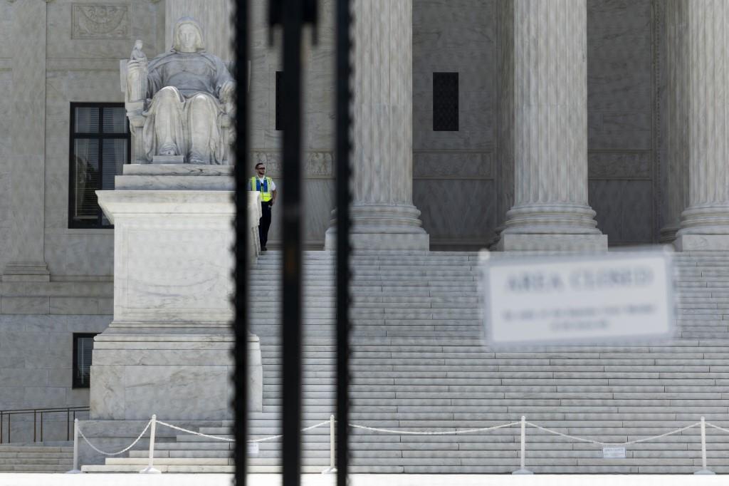 A Supreme Court police officer stands at the top of the stairs to the US Supreme Court building on June 20 in Washington DC. Photo: AFP