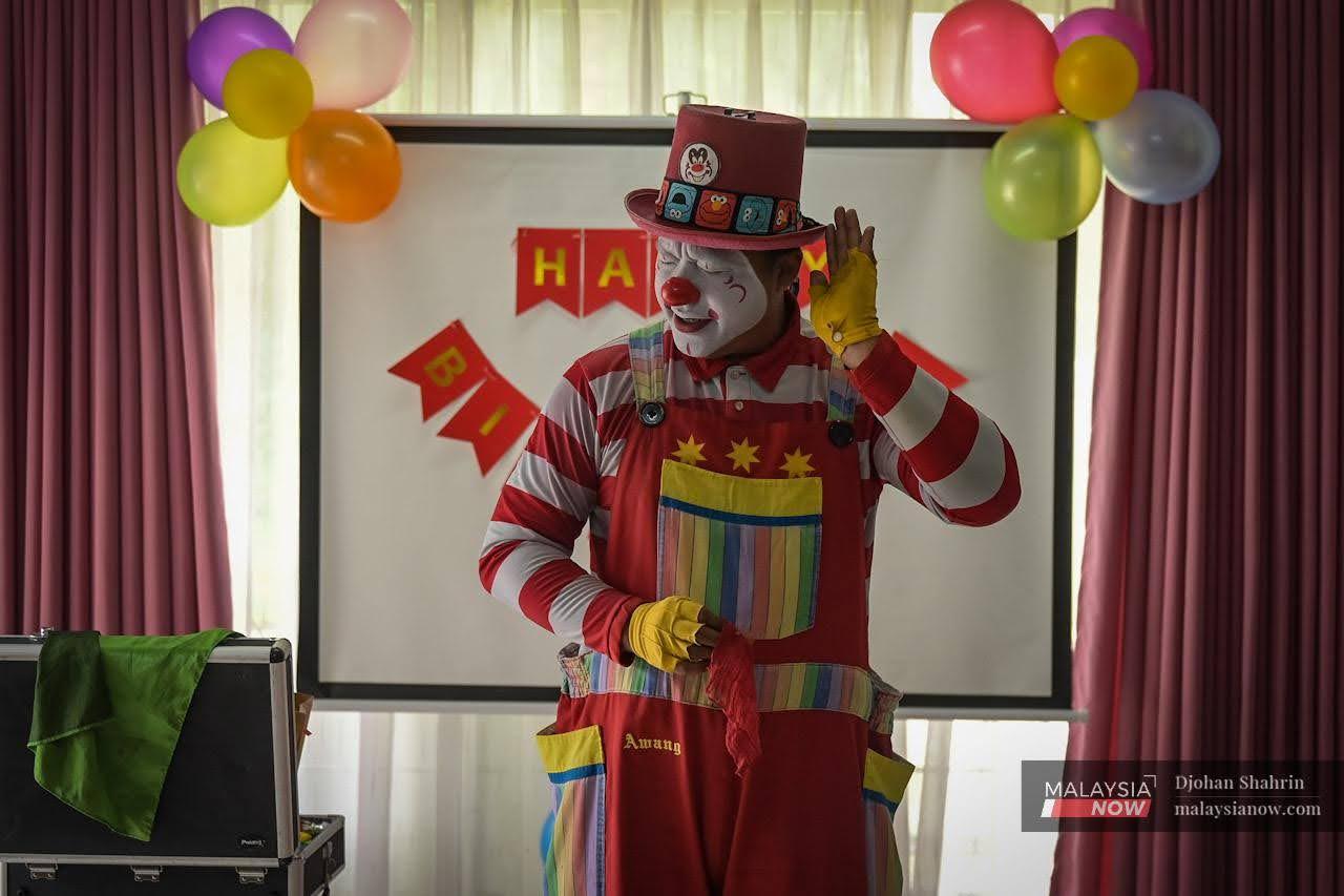 Mohd Fadly Abu Hasan aka Awang the Clown puts on a performance for children at a birthday party in Taman Lestari Perdana, Seri Kembangan in Selangor.