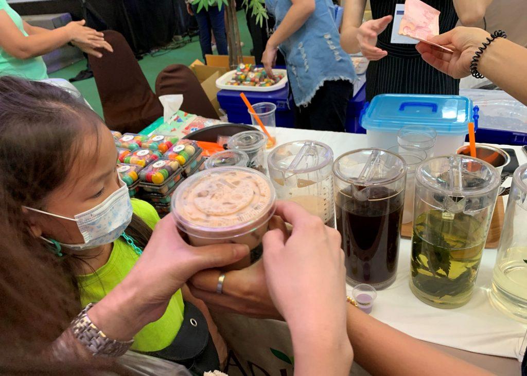 In this photo taken on March 21, 2021, a child looks at refreshment drinks infused with boiled cannabis leaves at a stall at the 'Ganja and Thai Traditional Medicine in the City' trade fair at a shopping mall in Bangkok. Photo: AFP