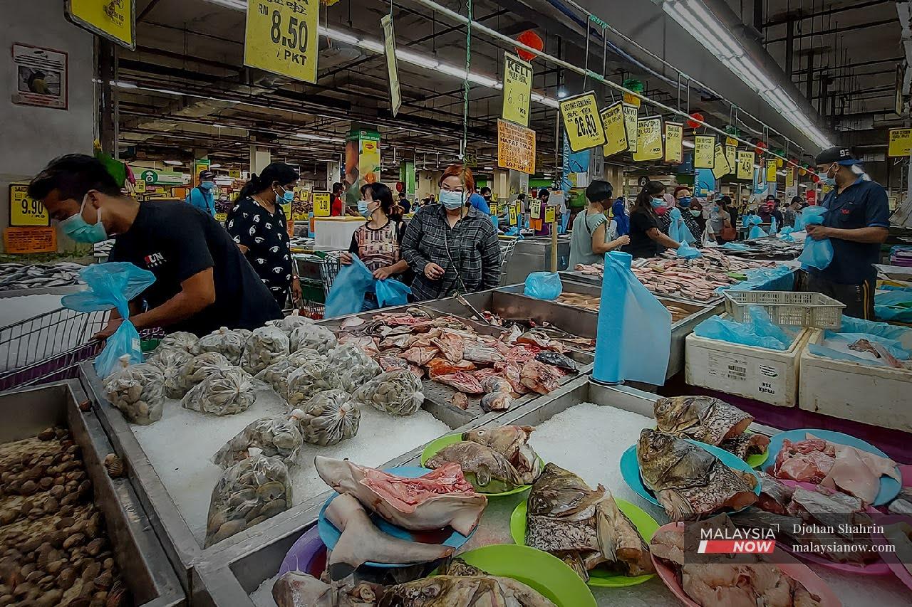 Customers queue at the seafood section of a supermarket in Taman Kuchai, Kuala Lumpur.