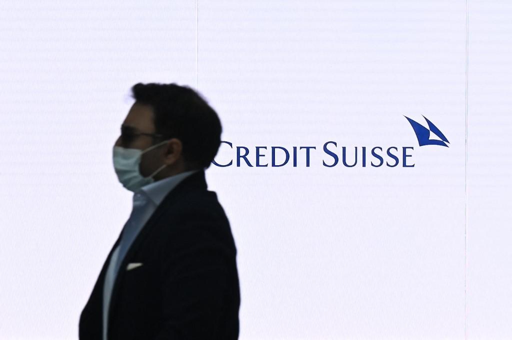 A man passes by a screen displaying the logo of Swiss bank Credit Suisse at the bank's headquarters in Zurich on Aug 9, 2021. Photo: AFP