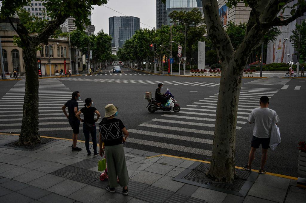 People wait to cross a street during a Covid-19 coronavirus lockdown in the Jing'an district of Shanghai on May 30. Photo: AFP