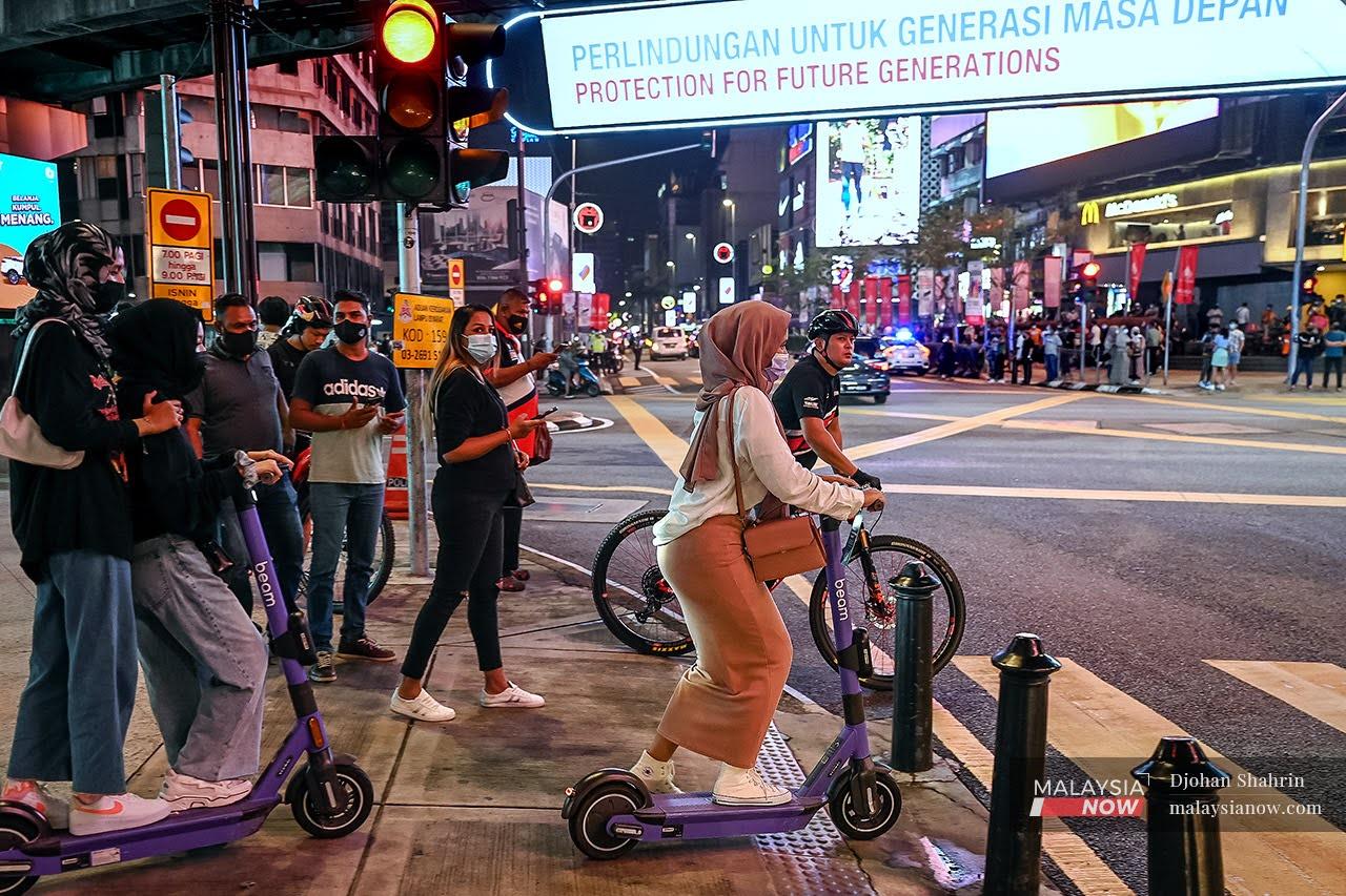 Pengunjung menggunakan skuter elektrik ketika bersiar-siar di Bukit Bintang, Kuala Lumpur.