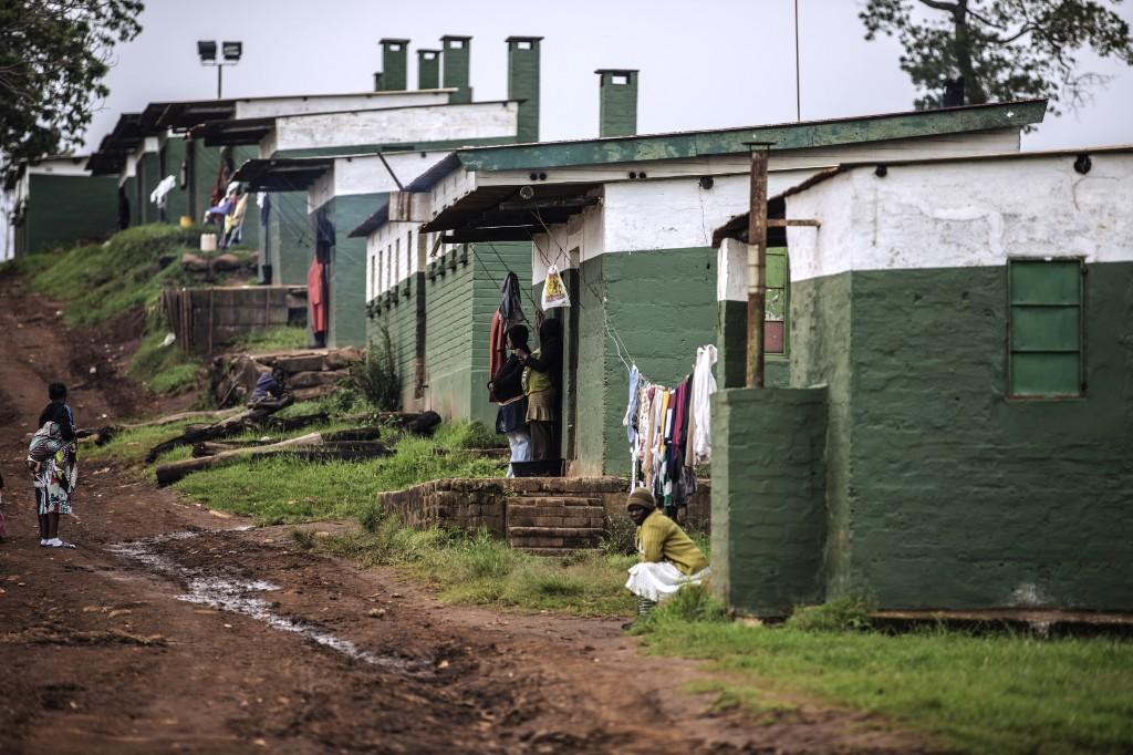 Farm workers from a Sugar Cane plantation stand outside of their homes on the outskirts of Eshowe, South Africa, on Nov 6, 2014. Photo: AFP