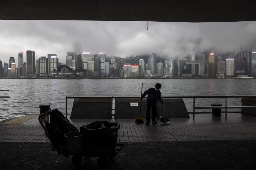 A street cleaner works on a promenade next to Victoria Harbour during a day of heavy rain in Hong Kong on June 8. While US officials have previously affirmed that China was generally complying with the restrictions, the US government has vowed to closely monitor compliance and rigorously enforce the regulations. Photo: AFP