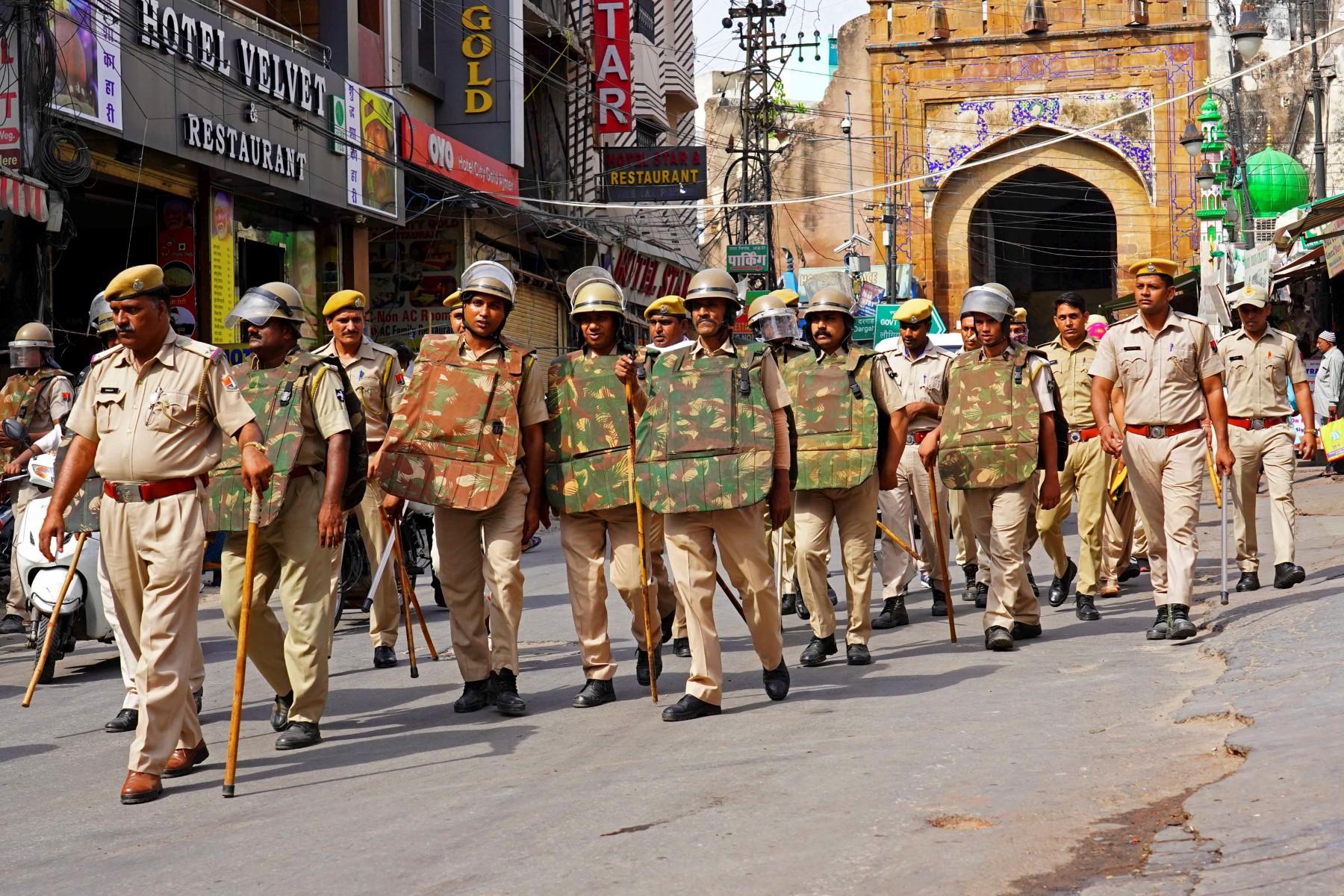 Policemen carry out a flag march through a street in Ajmer on June 29, following the alleged murder of a Hindu tailor by two Muslim men in Udaipur. Photo: AFP