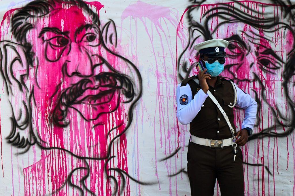 A policeman stands guard in front of a banner during an anti-government demonstration near the president's office in Colombo on April 22. The island nation is suffering a painful financial crunch after running out of foreign currency to pay for imported food, fuel, pharmaceuticals and other essentials. Photo: AFP