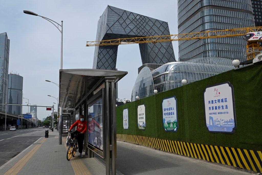 A man rides a bike past a bus station at central business district in Beijing on May 5. Photo: AFP