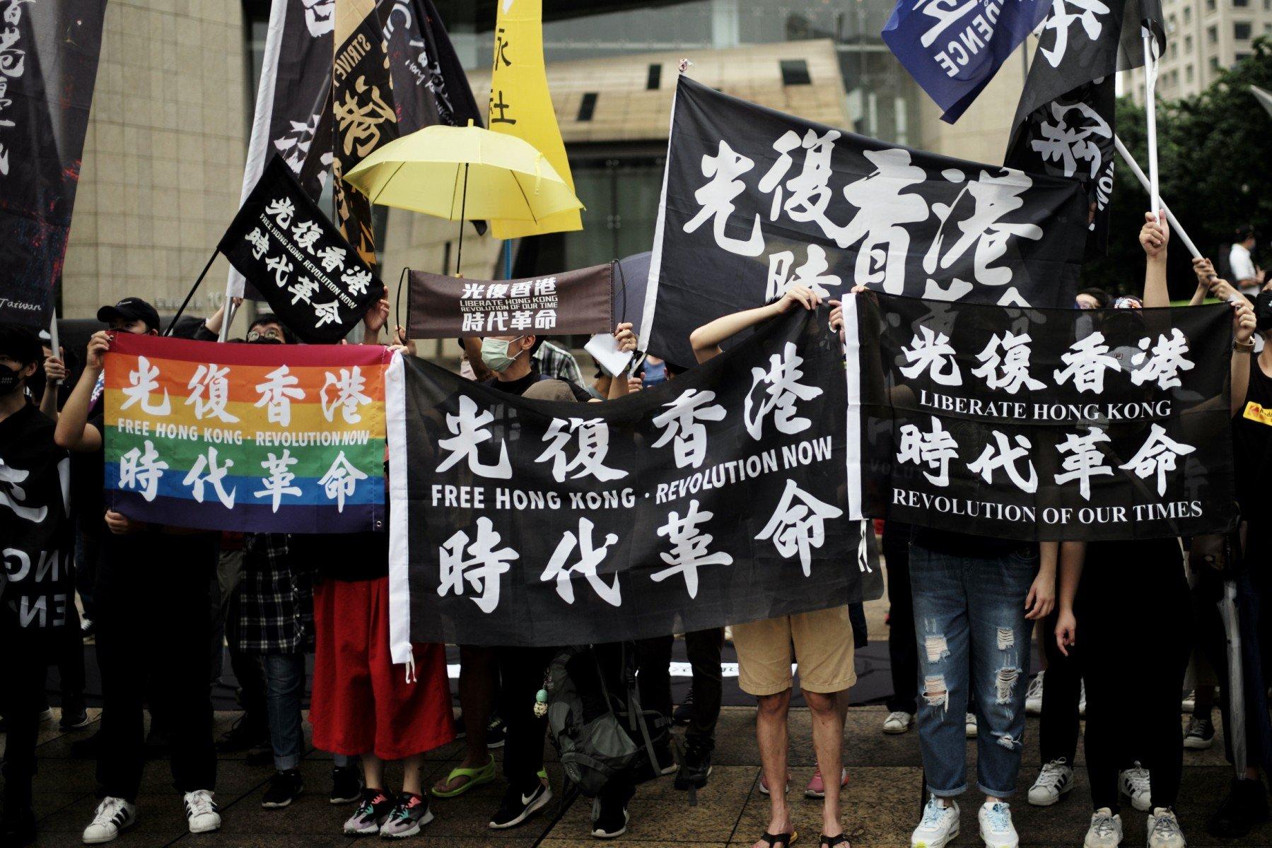 Activists hold flags that read 'Free Hong Kong, Revolution Now' during a rally to mark the third anniversary of the start of massive pro-democracy protests which roiled Hong Kong in 2019, in Taipei on June 12. Photo: AFP