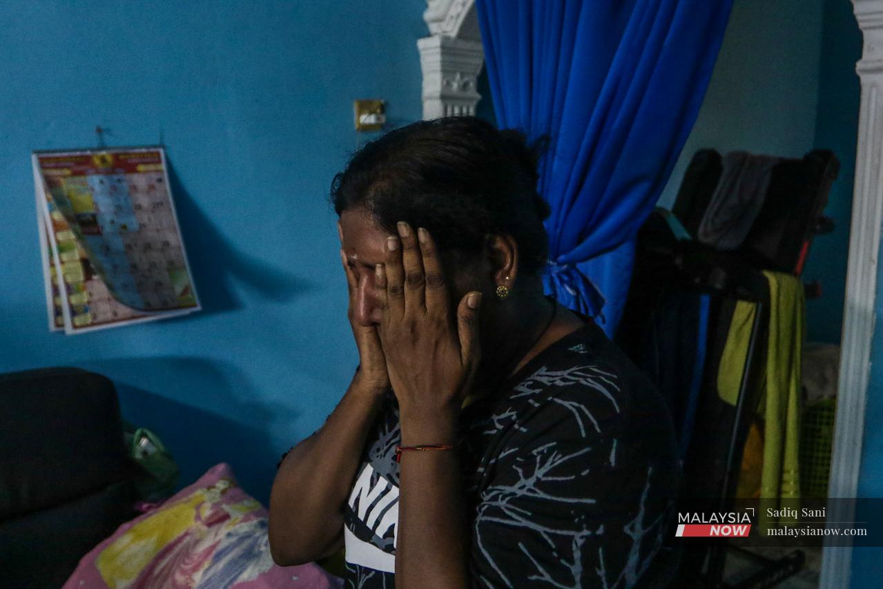 K Goomathi covers her face with her hands as she recalls the long years of caring for her two disabled children on her own.