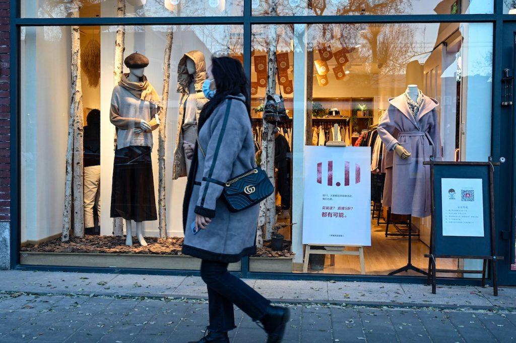 A woman walks past a clothing store on Nov 11. Two counties in the province – Sixian and Lingbi – announced lockdowns last week, with more than 1.7 million residents only permitted to leave their homes if they are getting tested. Photo: AFP