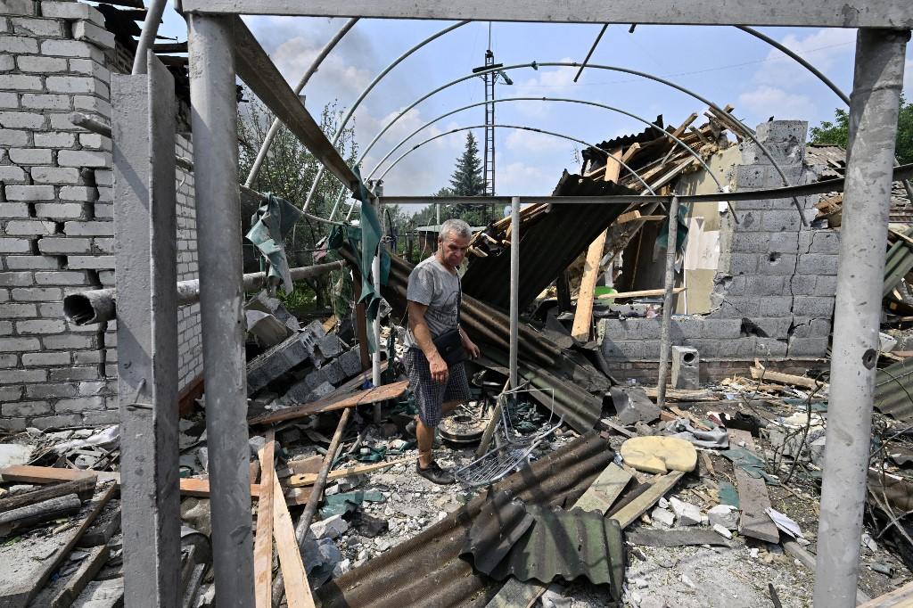 A resident walks among debris next to a destroyed house in Sloviansk on July 4, 2022, the day after a Russian rocket attack. (Photo by Genya SAVILOV / AFP)