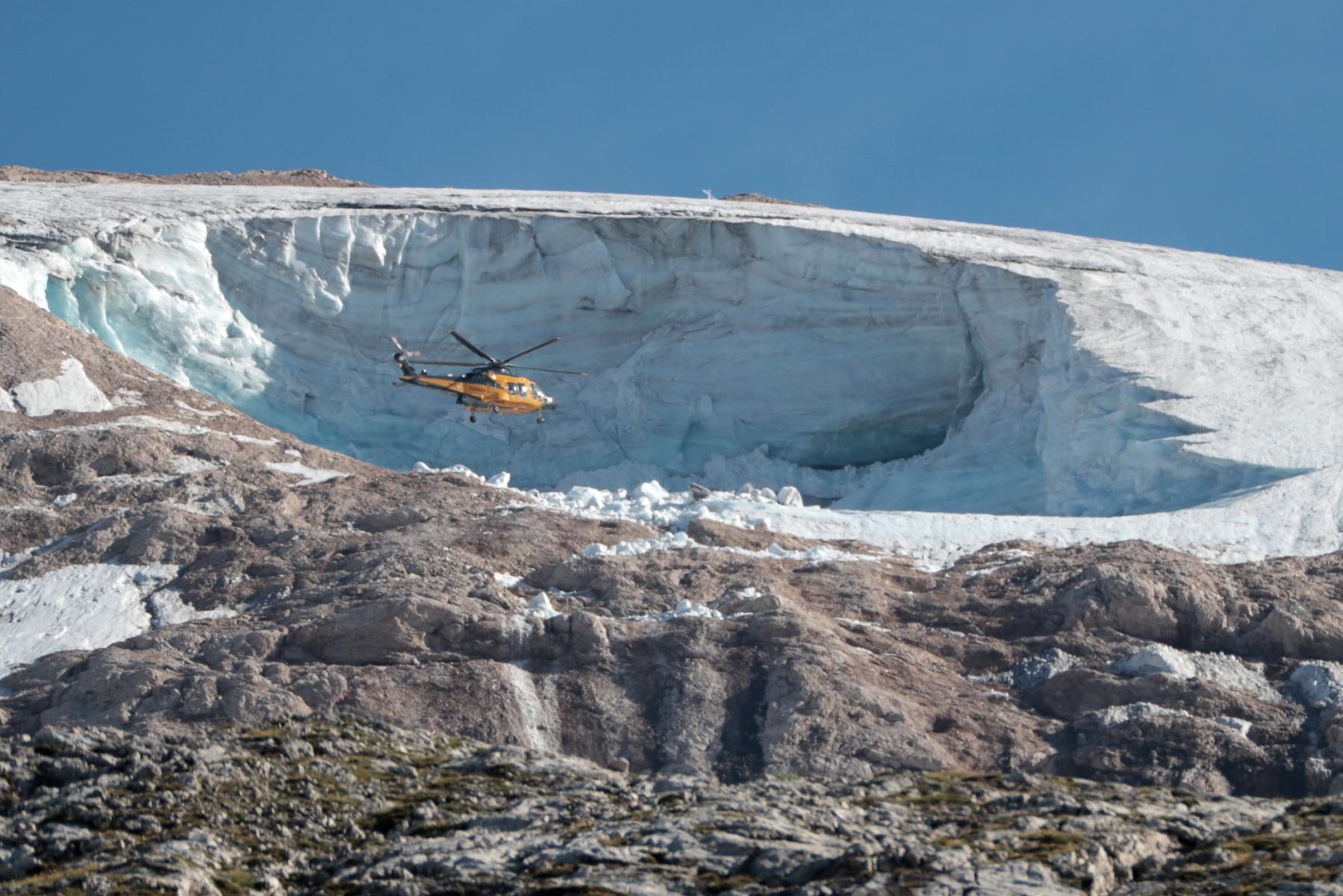 A 'Guardia di Finanzia' helicopter flies above the Marmolada glacier, near Canazei on July 4, one day after an ice serac collapsed, killing seven people. Photo: AFP
